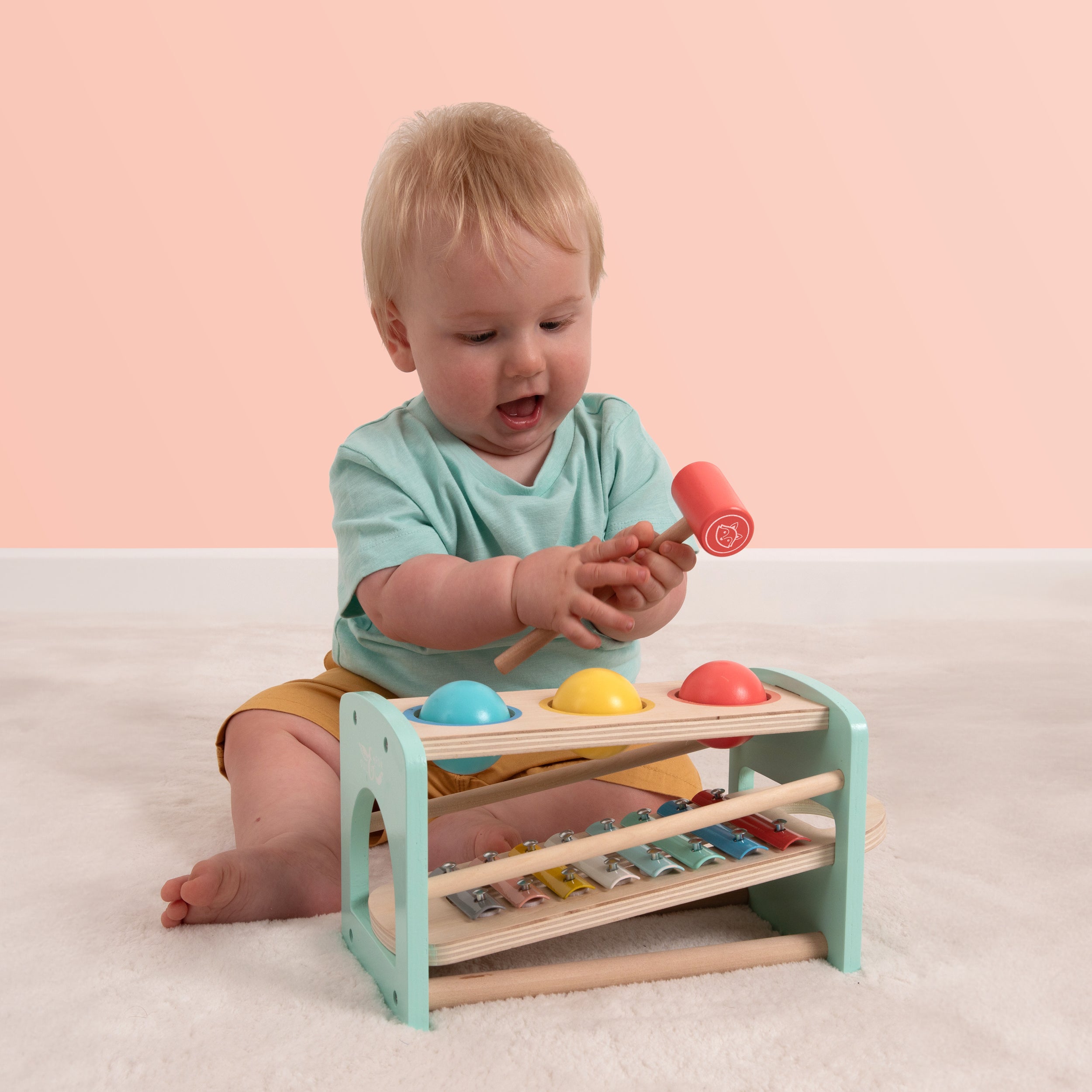  Toddler playing with a wooden Owl & Fox xylophone toy 