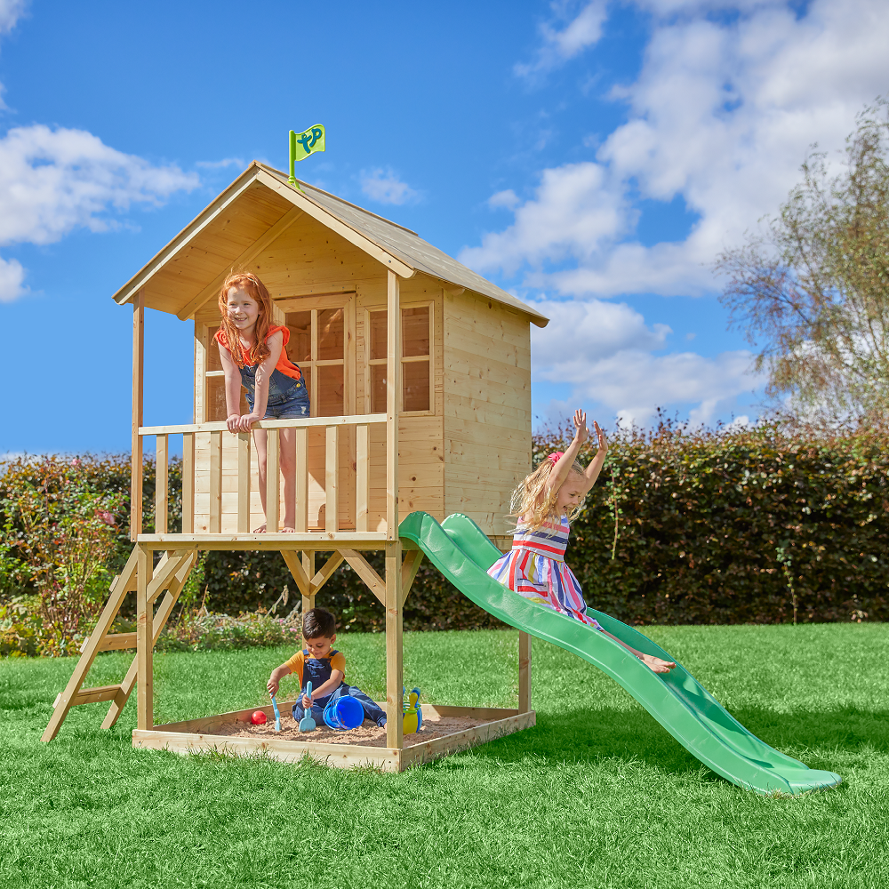  Children playing on wooden playhouse with slide 
