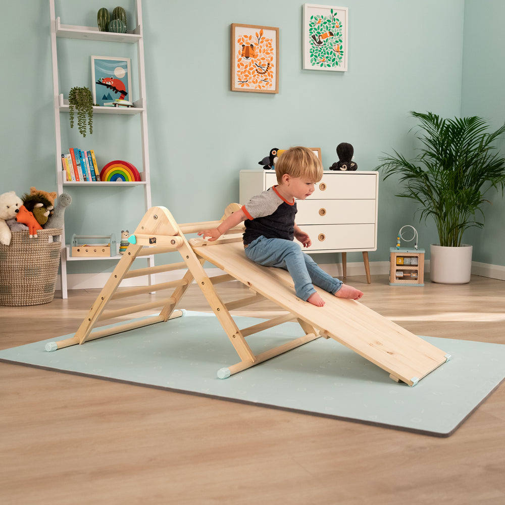 Child playing on wooden climbing triangle