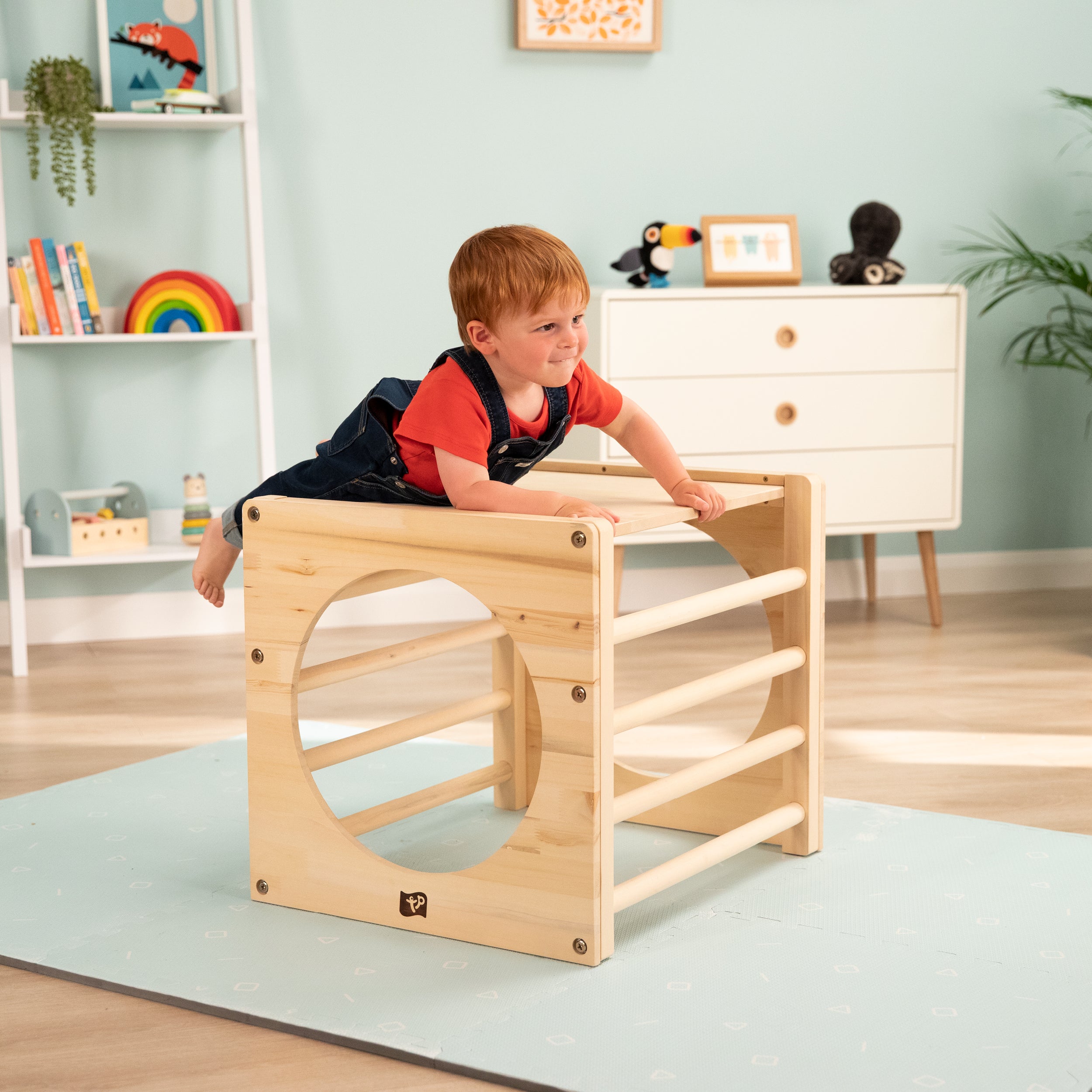  Child playing with wooden Pikler cube 